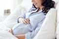 Close up of happy pregnant woman in bed at home Royalty Free Stock Photo