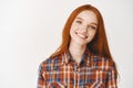 Close-up of happy redhead girl smiling at camera, standing on white background Royalty Free Stock Photo