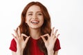 Close up of happy redhead woman with satisfied emotion, showing okay OK sign, praise good work, approve and like