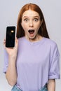 Close-up of happy shocked young woman in casual clothes showing phone with black empty mobile screen Royalty Free Stock Photo