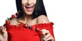 Close up of happy smiling brunette woman in red off shoulder dress holding giving small skewers with berries isolated on white.