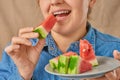 Close-up of a happy smiling Caucasian woman holding a slice of watermelon with her hand. Front view. Low angle view Royalty Free Stock Photo