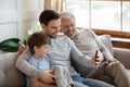 Close up happy three generations of men using smartphone together Royalty Free Stock Photo