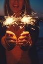 Close-up of happy woman with bright bruning sparklers in the night Royalty Free Stock Photo