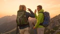 CLOSE UP: Happy woman and her boyfriend high five after reaching the mountaintop