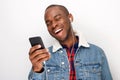 Close up happy young african american guy listening to music with smart phone and earphones Royalty Free Stock Photo