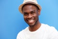 Close up happy young african american man with hat smiling against blue background Royalty Free Stock Photo