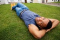 Close up happy young african man lying in grass and smiling Royalty Free Stock Photo