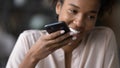 Happy young afro brazilian woman recording voice message. Royalty Free Stock Photo