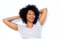 Close up happy young black woman with hands behind hair and smiling on white background Royalty Free Stock Photo