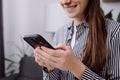 Close-up of happy young caucasian female holding smartphone, smiling girl making call, browsing, chatting on social network, Royalty Free Stock Photo