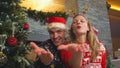 Cheerful couple sending kisses at camera while celebrating Christmas at home Royalty Free Stock Photo