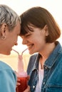 Close up of happy young lesbian couple having fun, drinking from one glass bottle with the straw, Two women enjoying Royalty Free Stock Photo