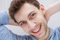 Close up happy young man smiling with hands behind head Royalty Free Stock Photo