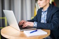 Close up happy young man works on his laptop to get all his business done early in the morning with his cup of coffee Royalty Free Stock Photo