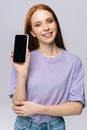 Close-up of happy young woman in stylish clothes holding cell phone with black empty mobile screen. Royalty Free Stock Photo