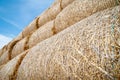 Close-up of hay bales on a blue sky background. Hay bales are stacked in large stacks. Royalty Free Stock Photo