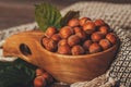 Close up of hazelnuts with green leaves in wooden bowl Royalty Free Stock Photo