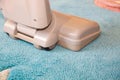 Close up of the head of a modern vacuum cleaner being used while vacuuming a thick pile white carpet Royalty Free Stock Photo