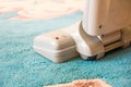 Close up of the head of a modern vacuum cleaner being used while vacuuming a thick pile white carpet Royalty Free Stock Photo