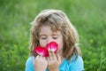 Close up head shot of child smelling flowers in spring nature park. Kids face, little boy portrait. Spring mood, enjoys