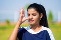 Close up head shot of Indian young woman doing nostril breathing or pranayama yoga or exercise with eyes closed at park Royalty Free Stock Photo