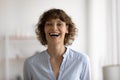 Close up head shot overjoyed woman laughing, looking at camera