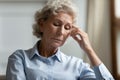 Elderly woman looks concerned sitting indoors thinking about life troubles Royalty Free Stock Photo