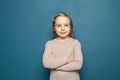 Close up head shot portrait with smiling little brown-haired girl. Happy beauty kid on blue background, seven year child looking Royalty Free Stock Photo