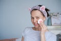 Close-up head shot smiling beautiful woman wrapped in towel applying toner Royalty Free Stock Photo