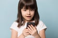 Close up excited preschool girl holding mobile phone.