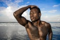 Portrait of young attractive and fit black African American man with strong muscular body posing cool model attitude on the beach Royalty Free Stock Photo