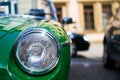 Close up of the headlight of a green classic sport car, with blurred background Royalty Free Stock Photo