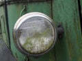 Close up of the headlight of an old abandoned truck with rusted green grille and panels Royalty Free Stock Photo