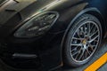 Close-up of Headlights, Wheel, and Rim of Black porsche sports car Royalty Free Stock Photo