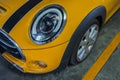 Close-up of Headlights, Wheel, and Rim of Yellow car