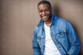 Close up headshot of a handsome african american man, stylish, cool, hip, casual jean jacket, with white teeth