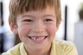 Close up headshot portrait of young little 7 or 8 years old boy with sweet funny teeth smiling happy and cheerful in joy face expr Royalty Free Stock Photo