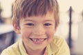 Close up headshot portrait of young little 7 or 8 years old boy with sweet funny teeth smiling happy and cheerful in joy face expr