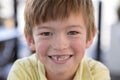 Close up headshot portrait of young little 7 or 8 years old boy with sweet funny teeth smiling happy and cheerful in joy face expr Royalty Free Stock Photo