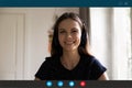 Headshot view of woman in earphones speak on video call