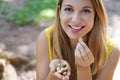 Close-up of healthy Brazilian woman picking Brazil nuts from her hand outdoors. Looks at camera Royalty Free Stock Photo