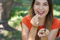 Close-up of healthy Brazilian woman picking Brazil nuts from her hand in park. Looks at camera Royalty Free Stock Photo