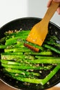 Close-up of healthy frying asparagus with salt and garlic in a frying pan. Delicious and healthy food Royalty Free Stock Photo