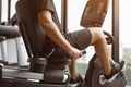 Close up healthy male is riding a spin bike in gym. Fitness man is doing cardio exercise on cycling bikes