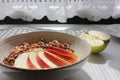 Healthy Walnut Red Apple Oatmeal in vintage bowl on white wooden table background. Natural lighting. Beautiful openwork shadow fro