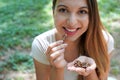 Close-up of healthy woman eating pecan nuts in the park. Looks at camera Royalty Free Stock Photo