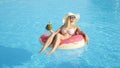 CLOSE UP: Healthy woman lying on pink floatie, sunbathing & drinking fresh juice Royalty Free Stock Photo