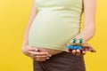 Close up of heap of blisters of pills in pregnant woman`s hand at colorful background with copy space. Healthcare and treatment