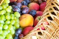 Close up heap of fresh fruits from new harvest poured out from wicker basket. Healthy meal concept. Autumn background. Royalty Free Stock Photo